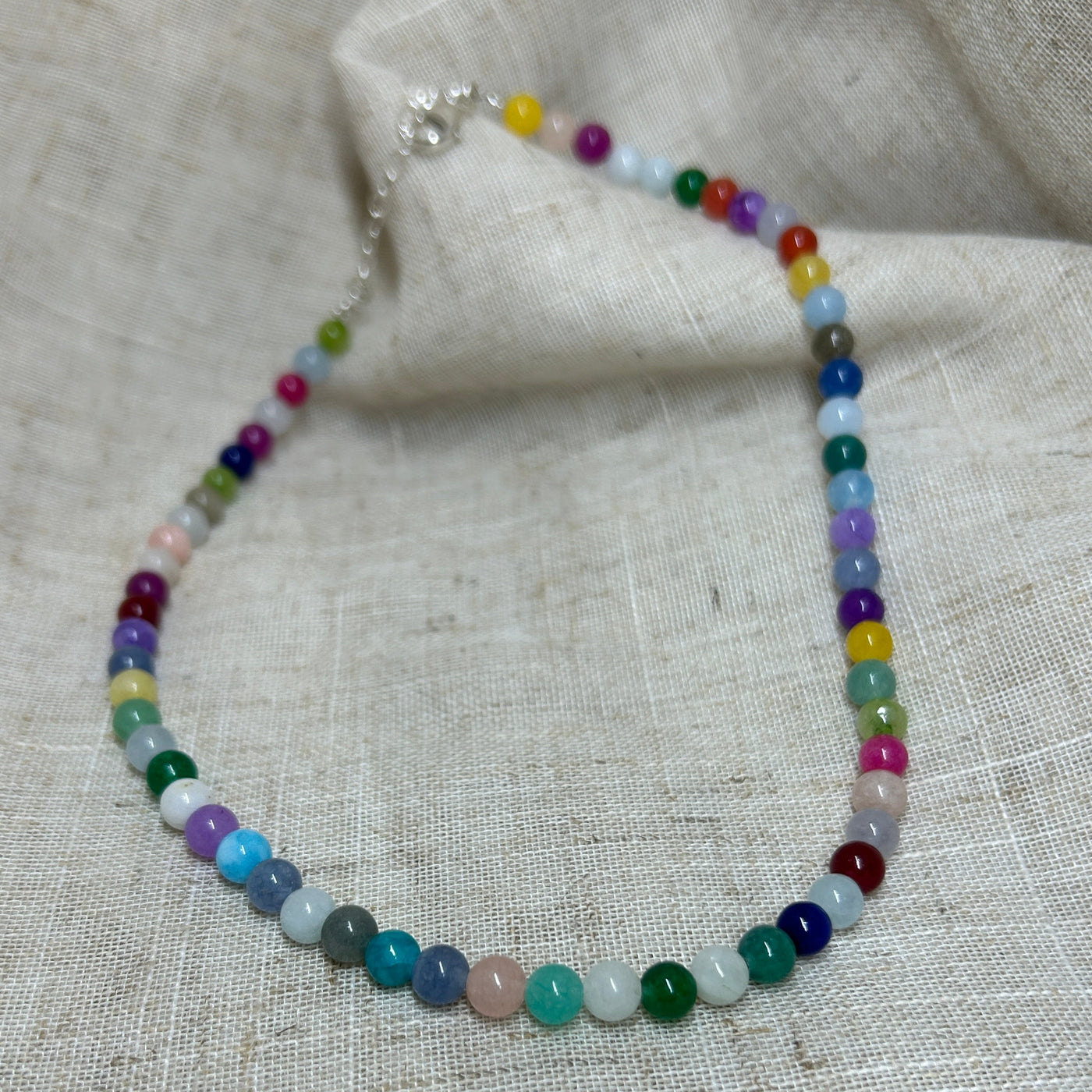 Multicolored beaded bracelet on a textured fabric background