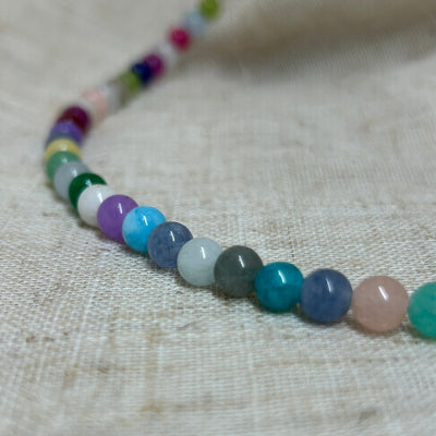 Necklace with multicolored beads on a textured fabric background