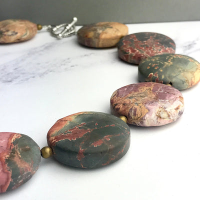 Necklace with marbled stone beads on a white surface