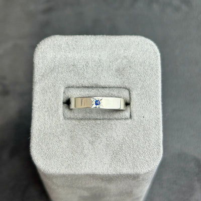 Sapphire ring in a grey jewelry box on a dark background