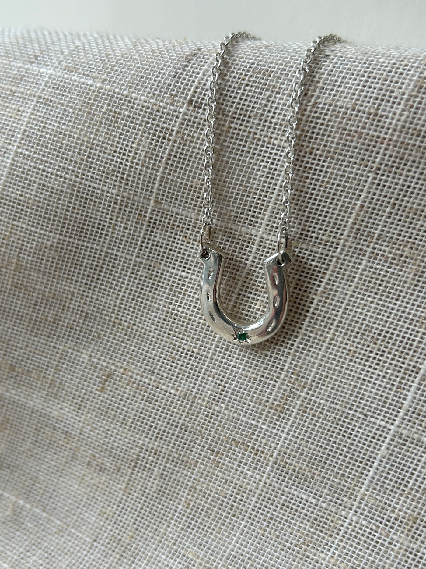 Close-up of a metal carabiner attached to a textured fabric background