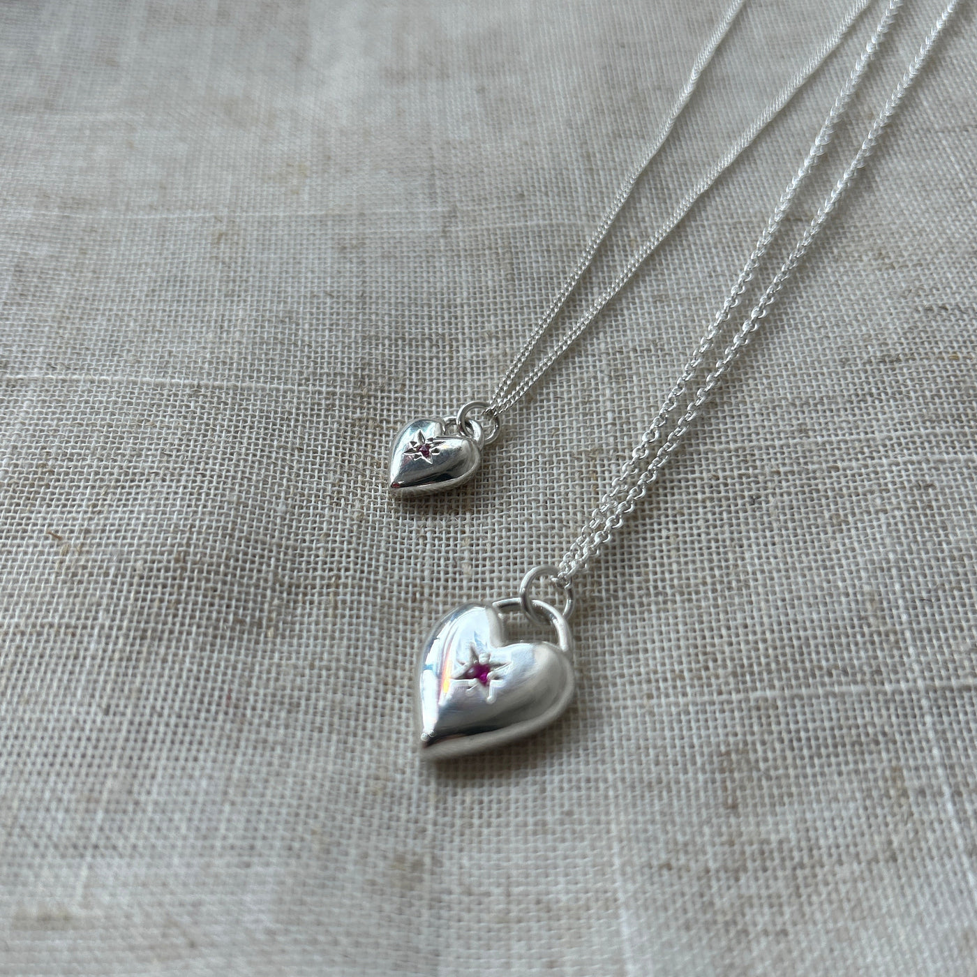 Silver heart-shaped necklace with a star detail on a textured gray surface