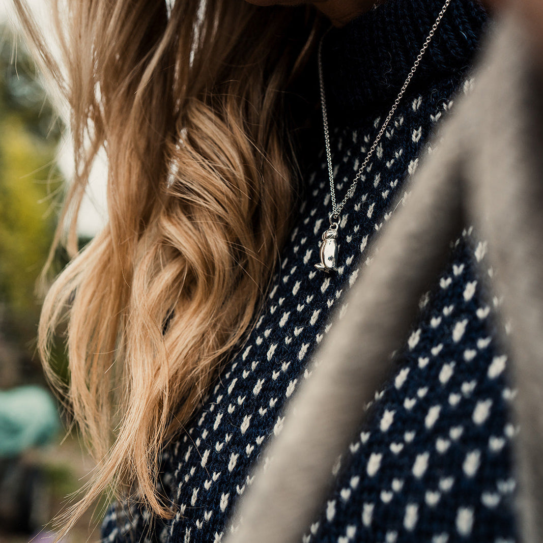 Silver Puffin pendant on a women with navy jumper